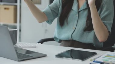 Ofiste bilgisayarla çalışan genç bir kadın.