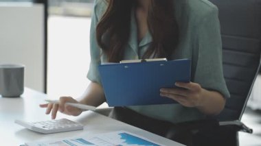 İş kadını dizüstü bilgisayarda çalışıyor ve ofisteki dijital tablet üzerindeki verileri analiz ediyor