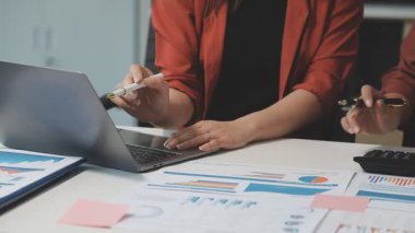 İş kadını mali tabloları analiz ederken hesap makinesi kullanıyor