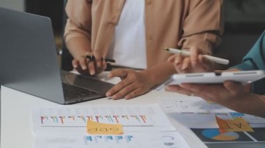 İş kadını ve işadamı finansal grafiği analiz etmek ve masadaki mali verileri analiz etmek için hesap makinesi kullanıyor