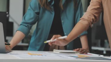 Genç iş kadınları ofiste yeni bir proje üzerinde çalışıyorlar.