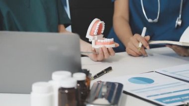 Doktor elinde ilaç şişesiyle arka planda haplar tutuyor.