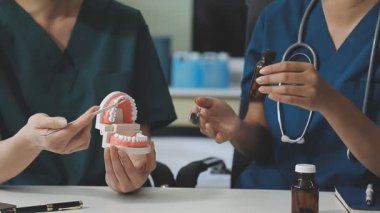 Doktor dişini dişçide hastaya gösteriyor..