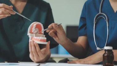 dişçi dişlerini gösteriyor ve kameraya gülümsüyor