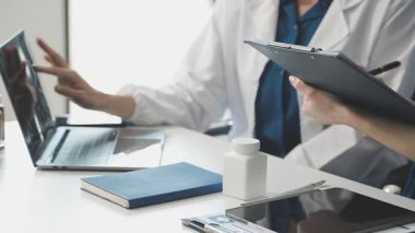 Doktor hastane ofisinde panoya yazı yazıyor..