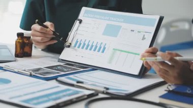 Doktor elinde dosyayla bir pano tutuyor.