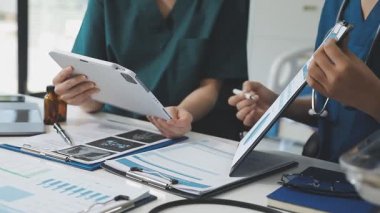 Ofiste bir tablet bilgisayarla çalışan bir grup doktor