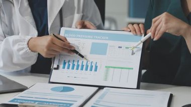 Doktor elinin kapağı panoda tıbbi raporları gösteriyor.