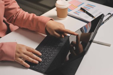 Ofisinde dizüstü bilgisayarla çalışan profesyonel bir iş kadınının görüntüsü. Genç bayan yönetici, modern çatı katında otururken taşınabilir bilgisayar kullanıyor. İşaret fişeği ışığı, iş süreci kavramı.