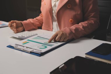 Ofisinde dizüstü bilgisayarla çalışan profesyonel bir iş kadınının görüntüsü. Genç bayan yönetici, modern çatı katında otururken taşınabilir bilgisayar kullanıyor. İşaret fişeği ışığı, iş süreci kavramı.