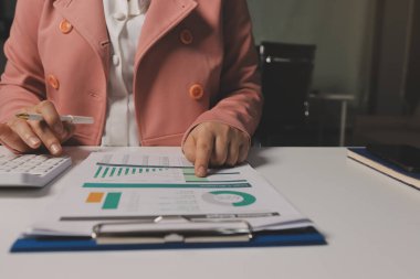 Ofisinde dizüstü bilgisayarla çalışan profesyonel bir iş kadınının görüntüsü. Genç bayan yönetici, modern çatı katında otururken taşınabilir bilgisayar kullanıyor. İşaret fişeği ışığı, iş süreci kavramı.