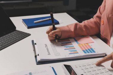 Ofisinde dizüstü bilgisayarla çalışan profesyonel bir iş kadınının görüntüsü. Genç bayan yönetici, modern çatı katında otururken taşınabilir bilgisayar kullanıyor. İşaret fişeği ışığı, iş süreci kavramı.