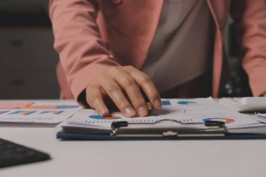 Ofisinde dizüstü bilgisayarla çalışan profesyonel bir iş kadınının görüntüsü. Genç bayan yönetici, modern çatı katında otururken taşınabilir bilgisayar kullanıyor. İşaret fişeği ışığı, iş süreci kavramı.