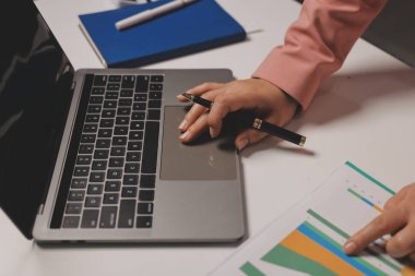 Ofisinde dizüstü bilgisayarla çalışan profesyonel bir iş kadınının görüntüsü. Genç bayan yönetici, modern çatı katında otururken taşınabilir bilgisayar kullanıyor. İşaret fişeği ışığı, iş süreci kavramı.