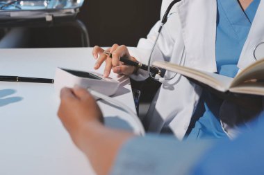 Steteskopla sfenometre kullanan bir doktor hastanede kan basıncını ölçüyor..