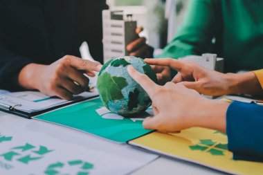 Genç Asyalı iş adamları ofiste yeniden kullanılabilir ürün tartışması, çevre dostu iş kurma, çevre koruma, sürdürülebilir iş modeli, ESG stratejisi, takım toplantısı, ev konseptinde çalışan insanlar