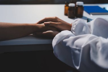 Yakın plan, doktor yaşlı bir kadınla el ele tutuşuyor ve kanser bakımı ya da destek. Sağlık hizmetleri veya güven, empati veya şefkat ve kadın bakıcı veya hemşire umut ve şefkat için yaşlı kişinin elini tutuyor.