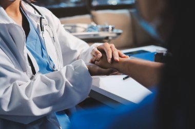 Yakın plan, doktor yaşlı bir kadınla el ele tutuşuyor ve kanser bakımı ya da destek. Sağlık hizmetleri veya güven, empati veya şefkat ve kadın bakıcı veya hemşire umut ve şefkat için yaşlı kişinin elini tutuyor.