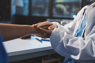 Yakın plan, doktor yaşlı bir kadınla el ele tutuşuyor ve kanser bakımı ya da destek. Sağlık hizmetleri veya güven, empati veya şefkat ve kadın bakıcı veya hemşire umut ve şefkat için yaşlı kişinin elini tutuyor.