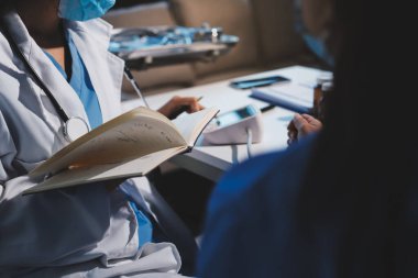 Steteskopla sfenometre kullanan bir doktor hastanede kan basıncını ölçüyor..