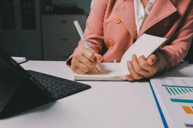 Ofisinde dizüstü bilgisayarla çalışan profesyonel bir iş kadınının görüntüsü. Genç bayan yönetici, modern çatı katında otururken taşınabilir bilgisayar kullanıyor. İşaret fişeği ışığı, iş süreci kavramı.