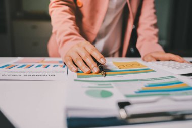 Ofisinde dizüstü bilgisayarla çalışan profesyonel bir iş kadınının görüntüsü. Genç bayan yönetici, modern çatı katında otururken taşınabilir bilgisayar kullanıyor. İşaret fişeği ışığı, iş süreci kavramı.