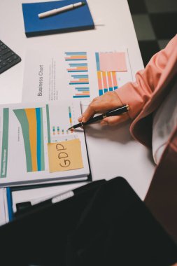 Ofisinde dizüstü bilgisayarla çalışan profesyonel bir iş kadınının görüntüsü. Genç bayan yönetici, modern çatı katında otururken taşınabilir bilgisayar kullanıyor. İşaret fişeği ışığı, iş süreci kavramı.