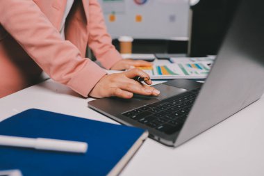 Ofisinde dizüstü bilgisayarla çalışan profesyonel bir iş kadınının görüntüsü. Genç bayan yönetici, modern çatı katında otururken taşınabilir bilgisayar kullanıyor. İşaret fişeği ışığı, iş süreci kavramı.