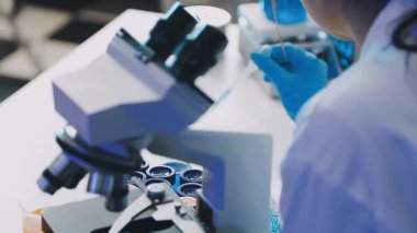 Laboratuvarda mikroskopla çalışan bilim adamlarına yakın çekim. tıbbi araştırma, sağlık ve bilim konsepti