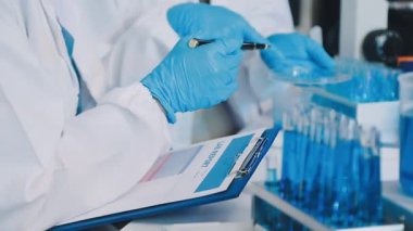 Laboratuvar ekipmanları üzerinde deney tüpüyle çalışan bilim adamlarının yakınına..