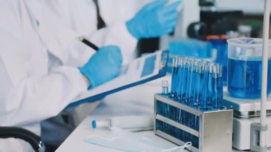 Laboratuvar asistanı elinde test tüpü tutuyor..
