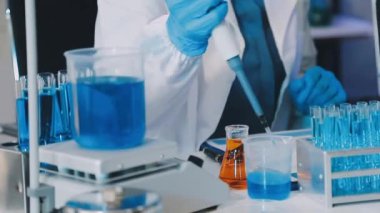 Test tüpü ve kimyasal sıvıyı elinde tutan laboratuvar asistanı..