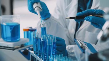 Laboratuvarda deney tüpüyle çalışan bilim adamı.