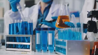 Koruyucu kıyafetli, koruyucu eldivenli bilim adamı laboratuarda çalışıyor.