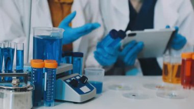 Laboratuvarda deney tüpüyle çalışan bir laboratuvar asistanı.