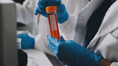 Laboratuvarda deney tüpü tutan bilim adamı.