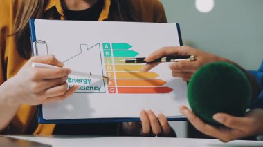 Elinde kalem ve yazılı kağıt tutan genç bir kadın.