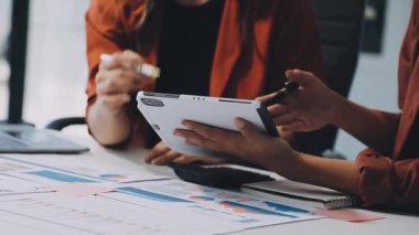 Genç Asyalı iş adamı ve kadın ofiste tartışıyor ve birlikte çalışıyorlar.