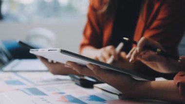 İş kadını iş yerinde elinde kalemle tablet tutuyor..