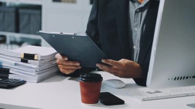 Modern ofiste bilgisayar ve belge kullanan bir iş adamı..