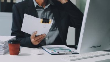 Genç işadamı ofisinde evraklarla çalışıyor.