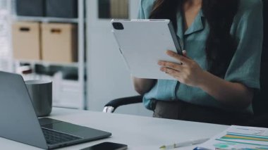 Ofiste tablet ve tablet kullanan bir kadın.