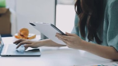 Ofiste tablet kullanan genç bir kadın.