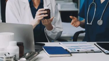 Doktorlar klinikteki bir masada çalışıyorlar.