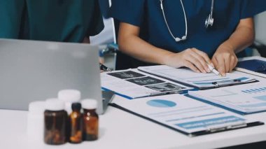 Modern hastanede çalışan beyaz üniformalı ve gözlüklü genç bir doktor.