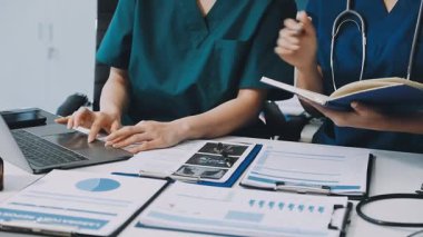 Hastanedeki bir hastayla bilgisayar üzerinde çalışan bir doktor kadın.