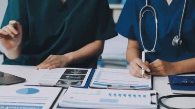 Tıbbi belgeleri olan doktor ve hasta teşhisin sonuçlarını tartışıyor..