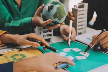 Genç Asyalı iş adamları ofiste yeniden kullanılabilir ürün tartışması, çevre dostu iş kurma, çevre koruma, sürdürülebilir iş modeli, ESG stratejisi, takım toplantısı, ev konseptinde çalışan insanlar