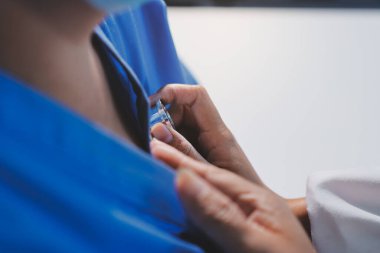 Ev bakımı hemşiresi ve yaşlılar kardiyoloji sağlık hizmetleri. Genç İspanyol kadın doktor hemşirenin yakın çekimleri sırasında steteskop kullanarak olgun beyaz hasta kalp atışlarını kontrol et.