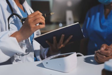Steteskopla sfenometre kullanan bir doktor hastanede kan basıncını ölçüyor..